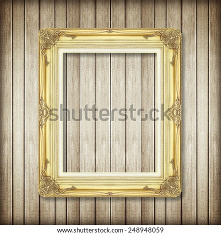 Antique picture frame on wooden wall ;. Empty picture frame on wooden wall.
