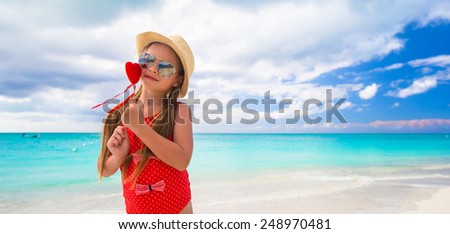 Adorable little girl with red heart in hands on Valentine's Day