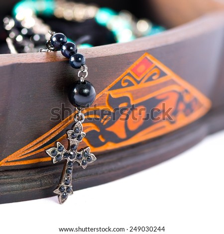 A rosary coming out of a carved box in wood