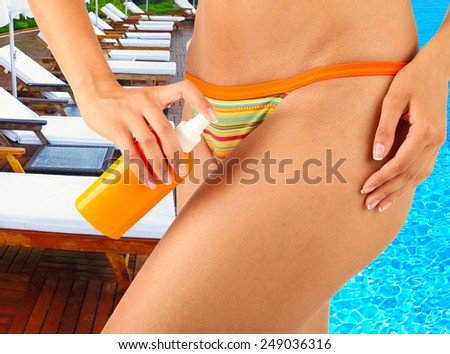 Young woman with slim body in swimsuit on swimming pool background