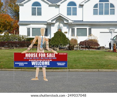 Mannequin wearing blue tie holding Real estate for sale open house welcome sign closeup of suburban mcmansion autumn day residential neighborhood USA