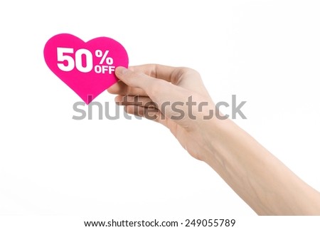 Valentine's Day discounts topic: Hand holding a card in the form of a pink heart with a discount of 50% on an isolated white background in studio