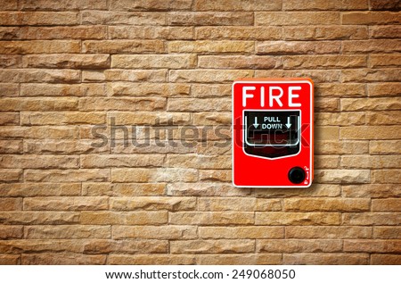 fire break glass alarm switch on the stone wall