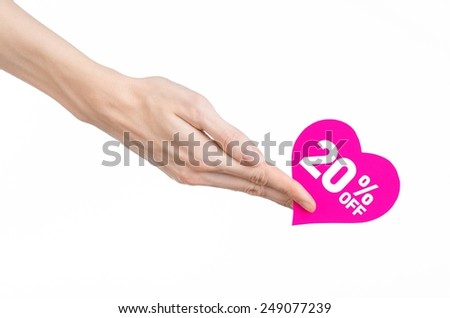 Valentine's Day discounts topic: Hand holding a card in the form of a pink heart with a discount of 20% on an isolated white background in studio