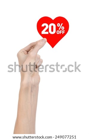 Valentine's Day discounts topic: Hand holding a card in the form of a red heart with a discount of 20% on an isolated white background in studio