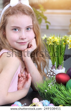 Preparing for Easter - girl helps in painting Easter eggs
