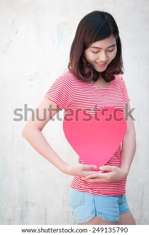 Woman holding a heart-shaped paper on white background