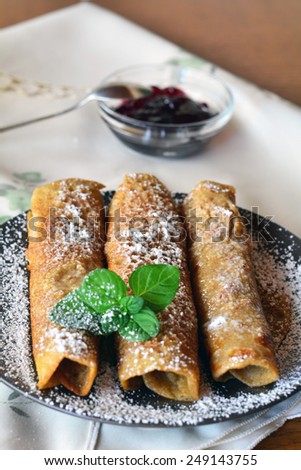 Sweet crepes with strawberry jam on the brown plate. Pancakes.
