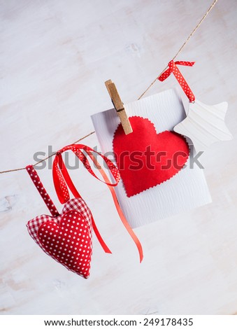 Love Valentine's hearts natural cord and red clips on rustic texture background, copy space