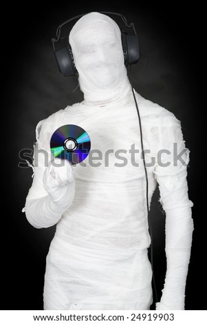 Man in bandage with ear-phones and disc on black