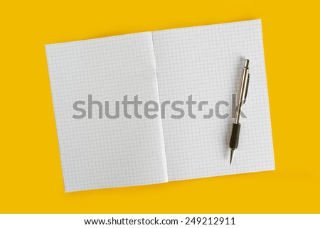 Ballpoint Pen and Blank Paper Notebook with as Business Copy Space on Yellow Background, top view