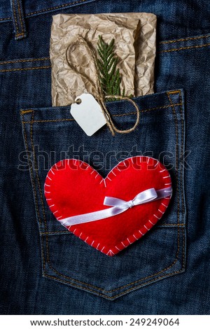 Red hand made heart for Valentine's Day on jeans background. Greeting Card with craft tag for message