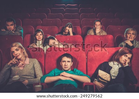 Group of people watching boring movie in cinema