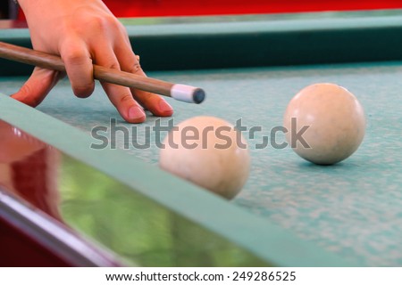 Hand with cue before the a blow to the billiard ball