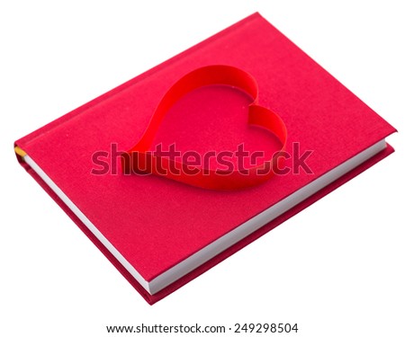 new book in red hard cover and paper tape in the shape of heart isolated on white background isolated on white background
