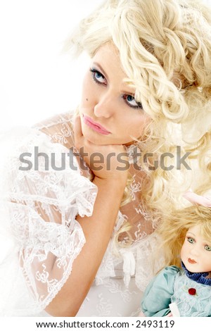 picture of unhappy bride holding doll over white