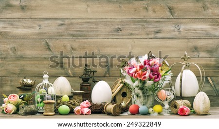 Easter decoration with pink tulip flowers and colored eggs. Vintage home interior. Retro style toned picture