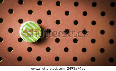 Round cute thumbtack or pushpin for whiteboard, notice board, gift card or special occasions with Love Forever message on polka dot vintage patterns background. Slightly defocused and close-up shot