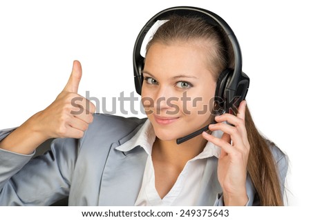 Businesswoman in headset showing thumb up, her other hand on microphone boom, looking at camera, smiling. Isolated over white background
