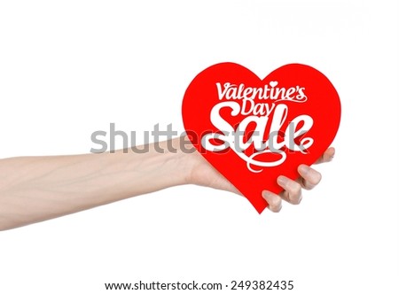 Valentine's Day and sale topic: Hand holding a card in the form of a red heart with the word Sale isolated on white background in studio