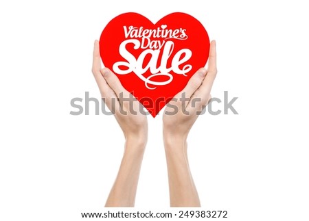 Valentine's Day and sale topic: Hand holding a card in the form of a red heart with the word Sale isolated on white background in studio