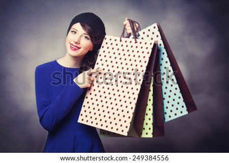 Portrait of beautiful women in blue dress with shopping bags and bokeh on background.