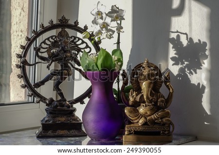 Still life with Ganesha (also known as Ganapati and Vinayaka), white orchid in violet vase and statue of the dancing Shiva
