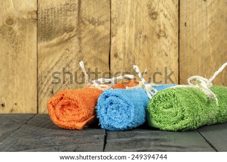 The towels rolled up and tied with string shown on the background of stained wood