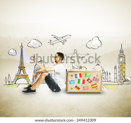 men with cellphone sitting near travel suitcase Royalty-Free Stock Photo #249412309