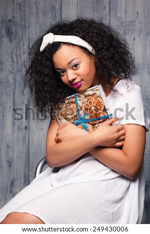 Beautiful happy young woman holding a  christmas gift,cookies