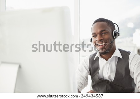 Smiling businessman with headset interacting in his office Royalty-Free Stock Photo #249434587