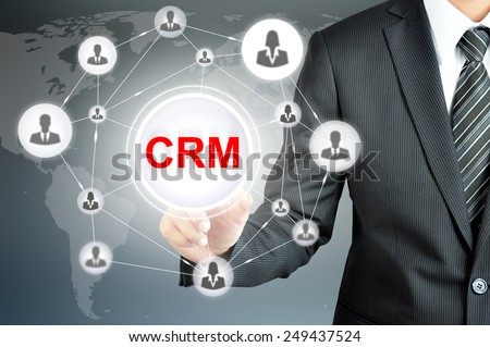Businessman pointing on CRM (Customer Relationship Management) sign on virtual screen with people icons linked as network