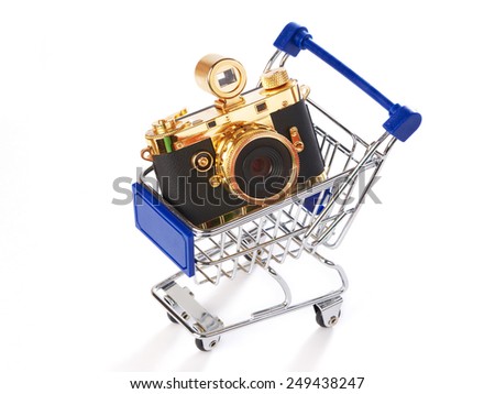 Shopping trolley with retro camera isolated on white background