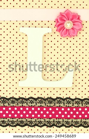 Wooden letter L on polka dots background
