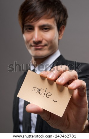 Smile word on yellow card holding by happy businessman of Asian.