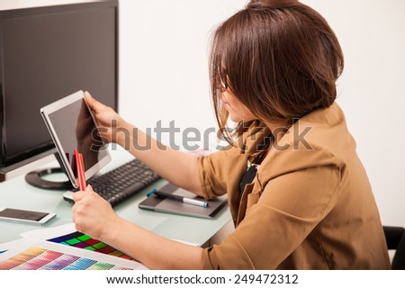 Attractive female designer using different types of technology for her work