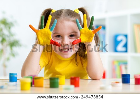 Portrait of child girl with face and hands painted at home Royalty-Free Stock Photo #249473854