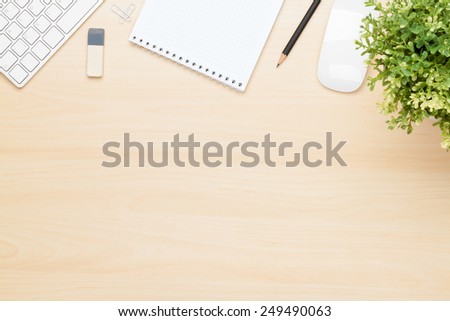 Office table with notepad, computer and flower. View from above with copy space