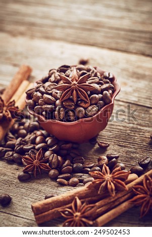 Coffee beans with cinnamon and anise on wooden background