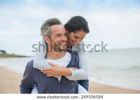 Portrait of a couple walking in the sand at the beach in casual clothes