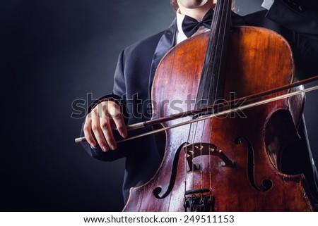 Cellist playing classical music on cello on black background