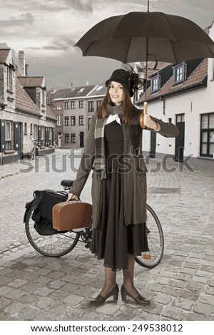 Young woman with umbrella outdoors. Mary Poppins version   Royalty-Free Stock Photo #249538012