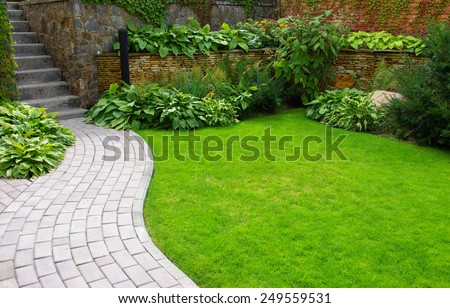 Garden stone path with grass growing up between the stones Royalty-Free Stock Photo #249559531