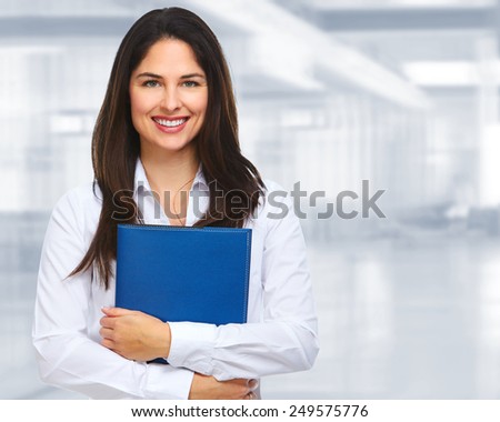 Young businesswoman with folder over office background.