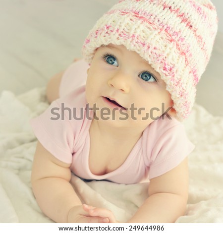 A cute little baby. Newborn baby girl in pink knitted hat. Parenting or love concept. Toned photo.