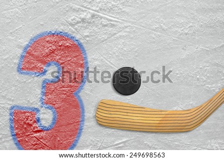 Hockey stick, puck and the numeral three painted on the ice
