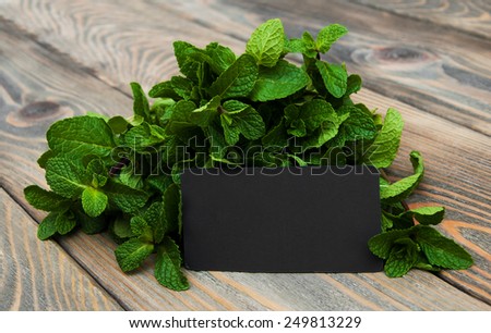 Leaves of mint with label on a old wooden background