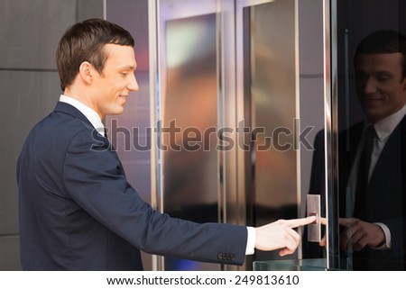 Man pressing red elevator button. side view of businessman pushing elevator button 