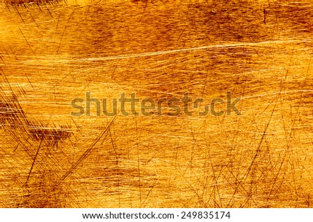 Scratches on a metallic gold background.