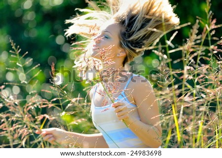 happy young woman on field in summer